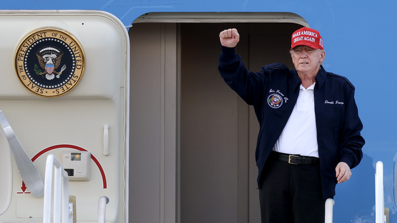 U.S. President Donald Trump gestures as he departs Air Force One at Miami International Airport on February 19, 2025 in Miami, Florida.