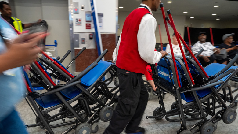 A worker pushes airport wheelchairs through Hartsfield-Jackson Atlanta International Airport on June 28, 2024 in Atlanta, Georgia.