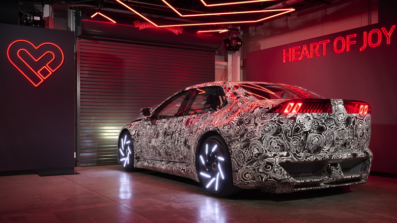 rear three quarters shot of the Vision Vehicle parked in a garage with its wheels lit up white