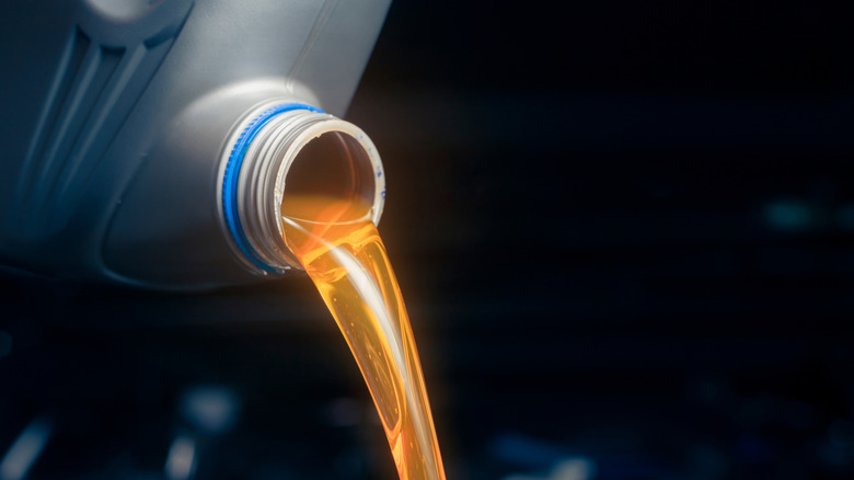 A photo of engine oil pouring from a bottle.