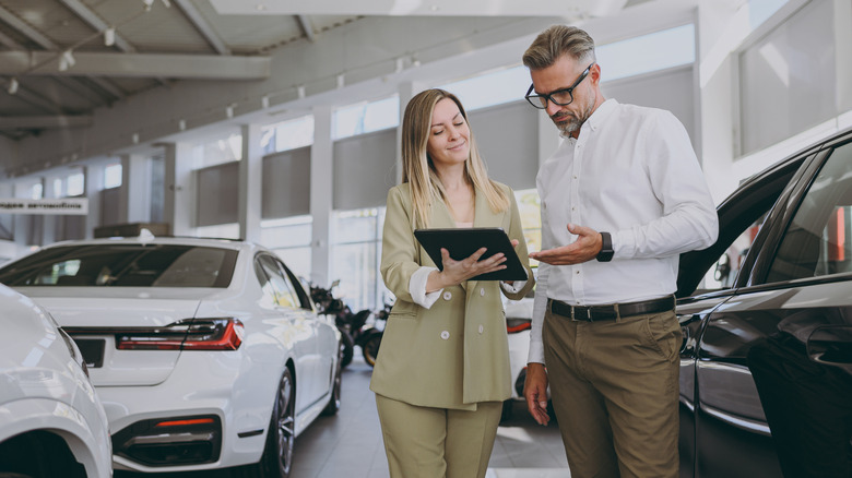 car sales person sells car to man