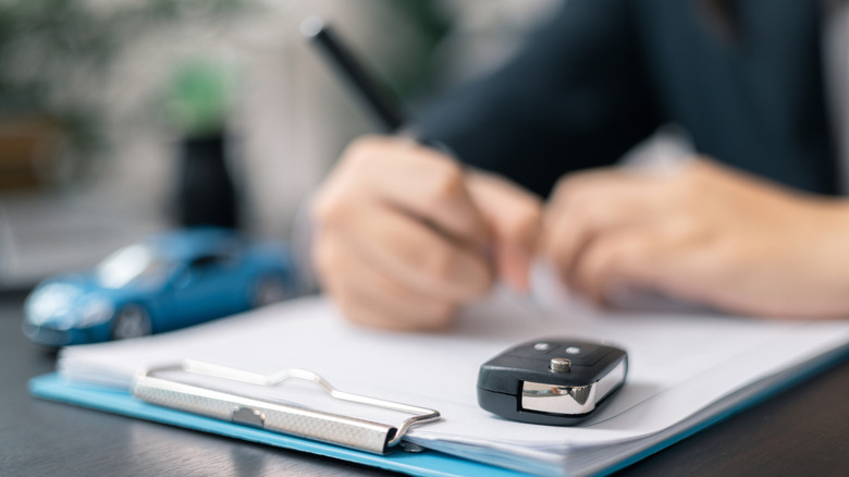 used car dealership signing paperwork