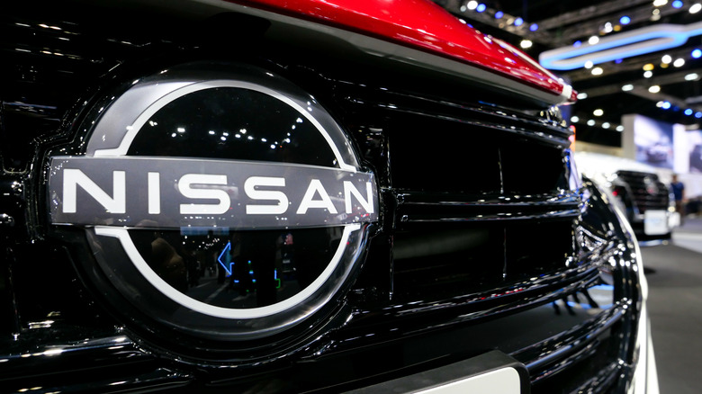 A photo of a Nissan badge on a car.