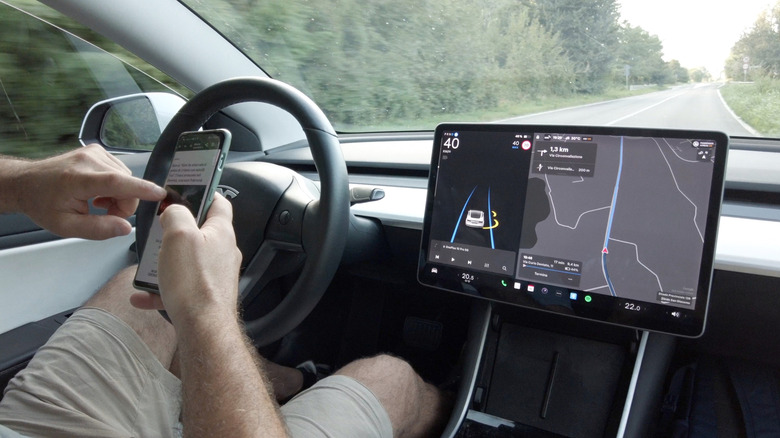 A photo of a person using their phone while driving.