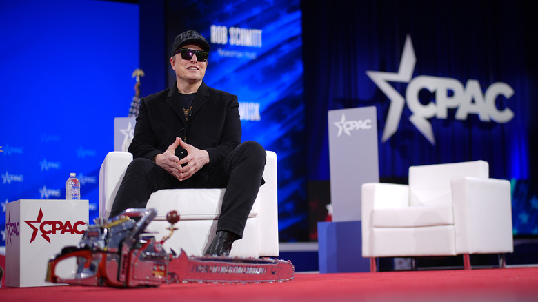 CEO of Tesla and SpaceX Elon Musk sits next to a chainsaw at the Conservative Political Action Conference (CPAC) at the Gaylord National Resort Hotel And Convention Center on February 20, 2025 in Oxon Hill, Maryland.