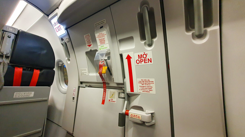 A photo of an emergency exit door on a plane.