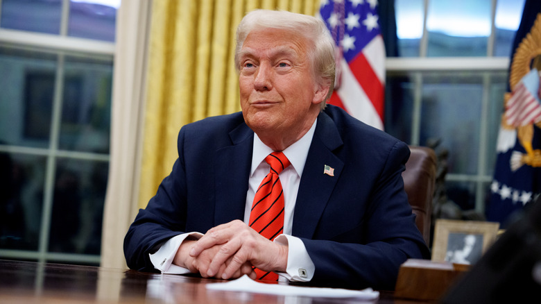 A photo of Donald Trump sitting at a desk.