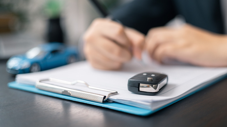 A car key on top of loan documents