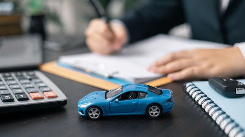 Toy car on the desk of a car dealer