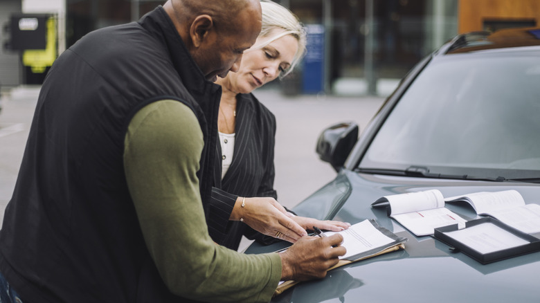 People negotiating at a car dealership