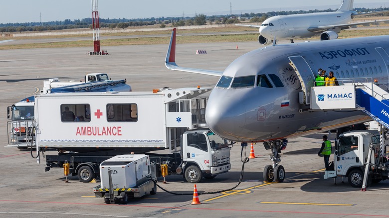 An airport ambulance approaching an Aeroflot plane on the tarmac