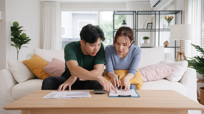 Man and woman looking at bills