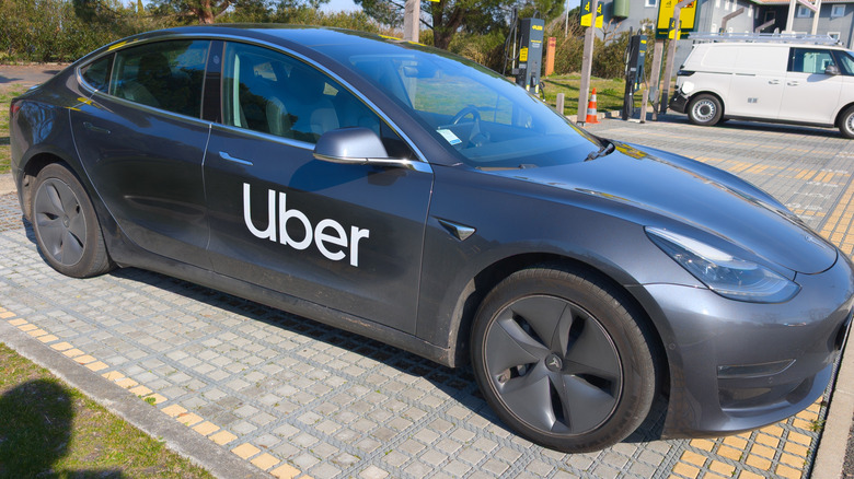 uber car brand text and logo sign on side taxi tesla ev electric vehicle for carrying passengers in street city