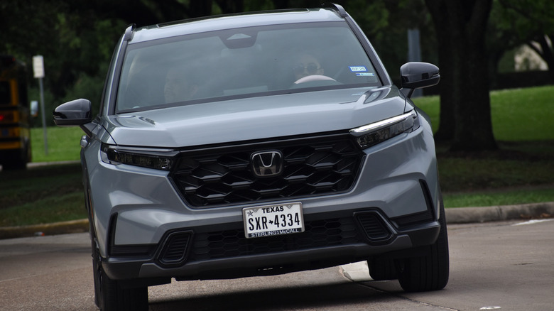 Hermann Park, Summer 4/29/2023 - Portrait of a Honda CRV Hybrid SUV cruising through Hermann Park in Houston