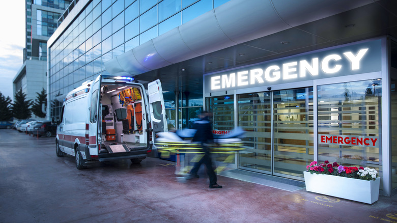 Paramedics taking patient on stretcher from ambulance to hospital