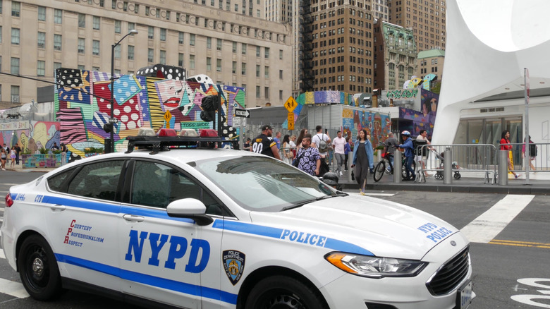 Police patrol car, USA NYPD, 911 vehicle on Manhattan Downtown Greenwich street, Oculus. American cop auto. Urban road traffic, people crossing on zebra.