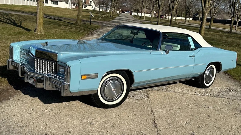 light blue cadillac eldorado convertible parked near trees