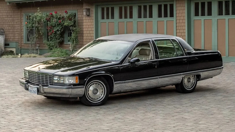 black cadillac fleetwood parked in front of a home