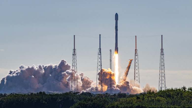 SpaceX Falcon 9 rocket and satellite payload launch in Florida. Booster are re-usable and either land at Cape Canaveral or on a barge at sea.