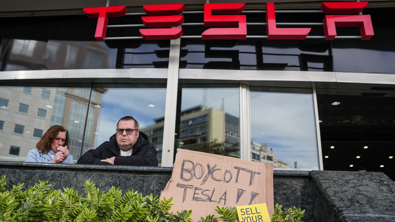 A photo of a protest outside a Tesla dealer.