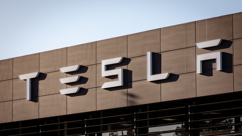 A photo of the Tesla logo on the side of a building.