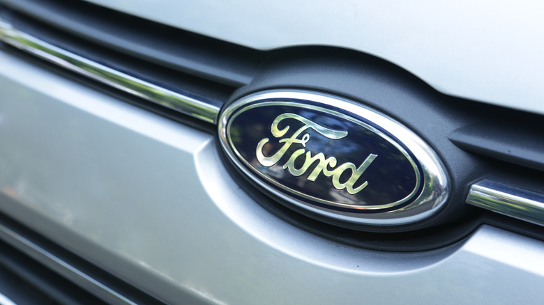 A photo of a Ford logo on the front of a car.