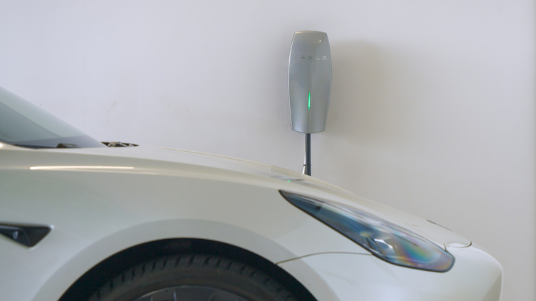 A photo of a Tesla car charging at home.