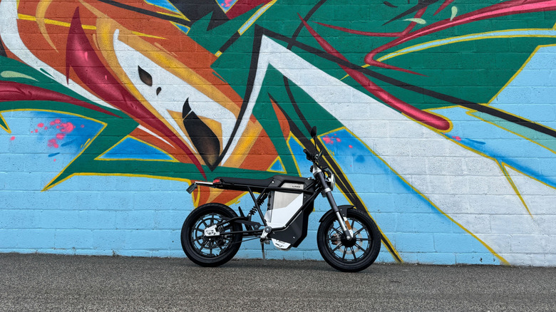 Land Moto in front of a mural