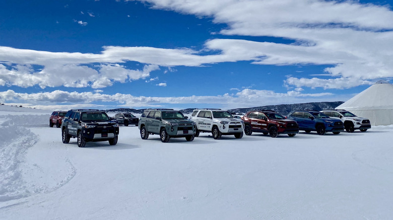 several Toyota SUVs lined up next to eachother on snow