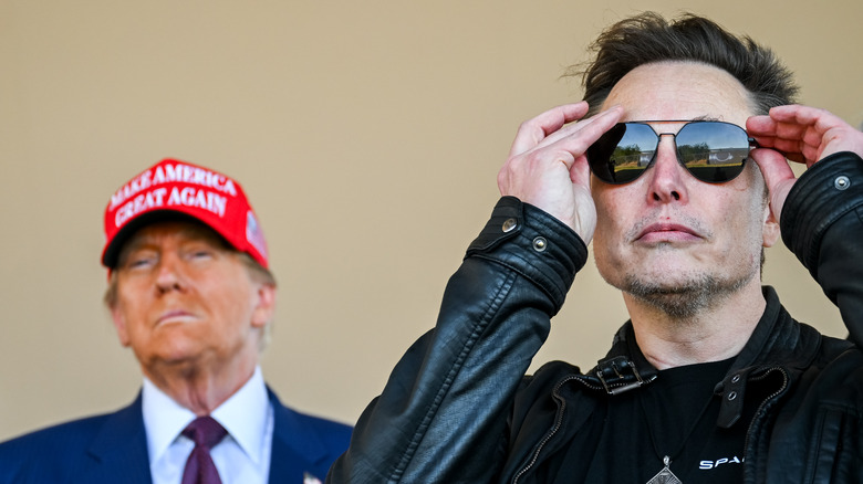 President trump looking very orange in the background while elon musk wears aviators in the foreground