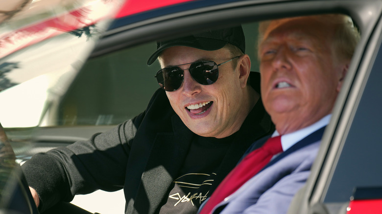 Elon Musk licking his teeth while sitting next to donald trump