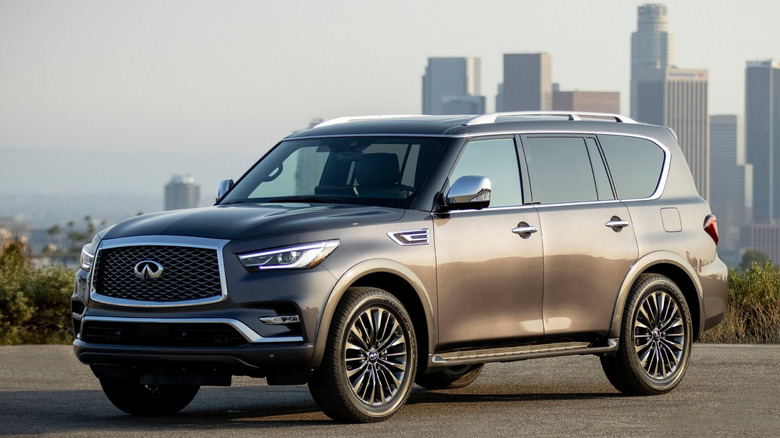 A photo of a black Infiniti SUV against a city.