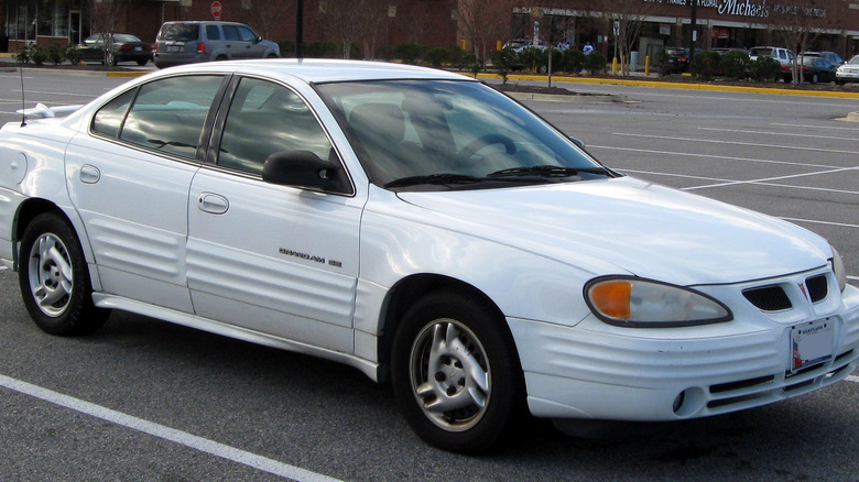 a white trans am sedan parked in a lot