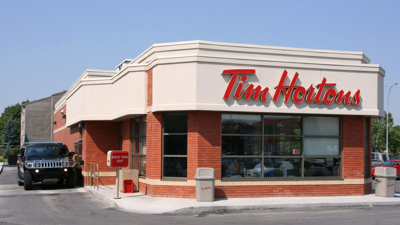 a tim hortons coffee shop with a hummer h2 in the drive thru