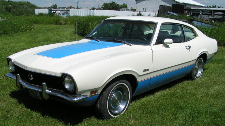 a white ford maverick with blue details parked on grass