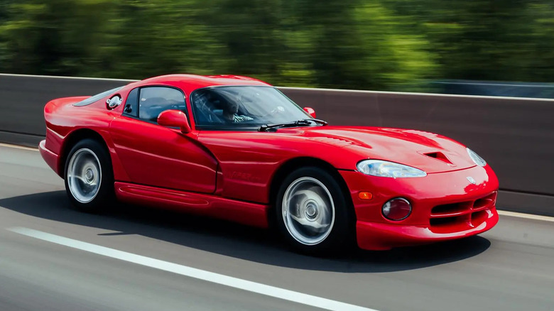 a red dodge viper driving on a freeway