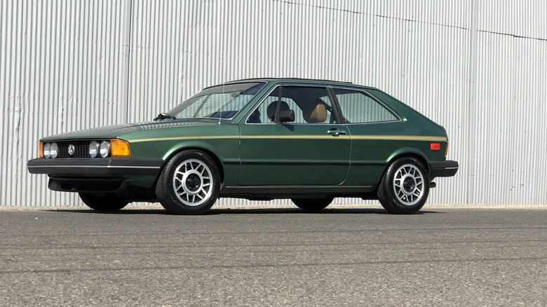 A perfect green VW Scirocco parked in front of a wall