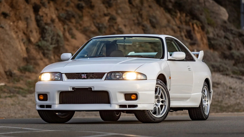 a white GTR parked in front of a mountainside