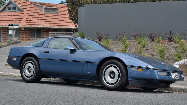 A blue corvette parked in front of a home