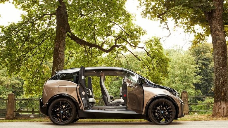 bmw i3 parked in front of trees with all its doors open