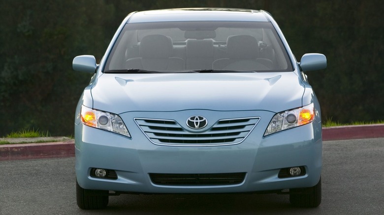 A Light blue camry parked facing the camera