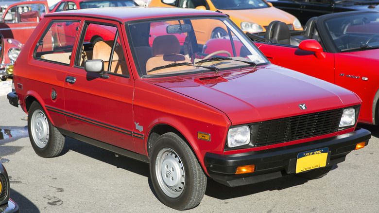 A 1987 Yugo GV in burgundy with dealer-installed decals and tan interior.