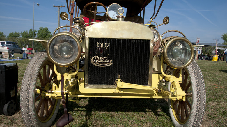 A rare Cartercar in yellow parked on the grass