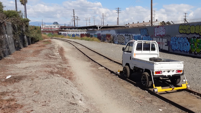 A screenshot of a kei truck driving on tracks.