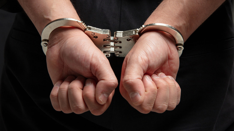 A photo of hands with handcuffs on.