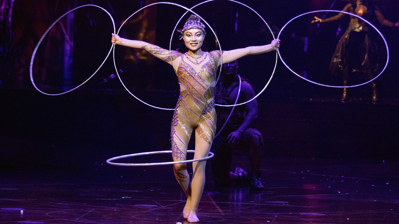 A photo of a circus performer using a hula hoop.