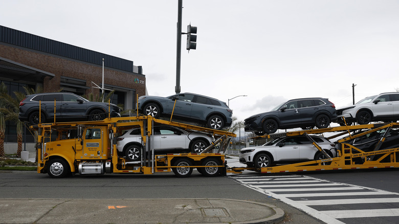 A truck carries brand new cars on March 04, 2025 in Richmond, California. U.S.