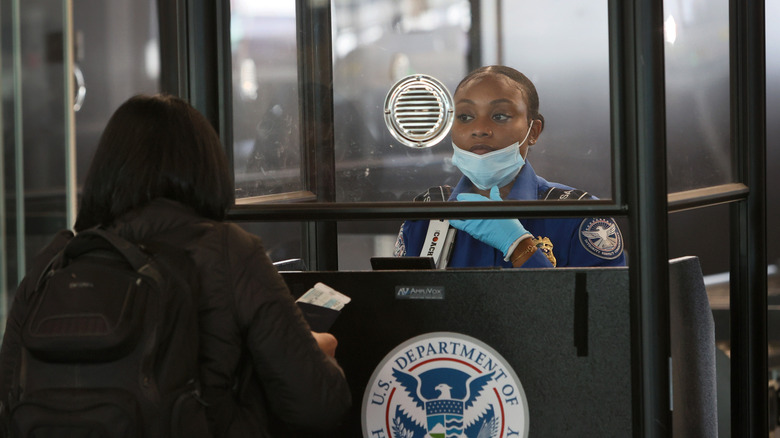 A TSA worker talks to a flyer