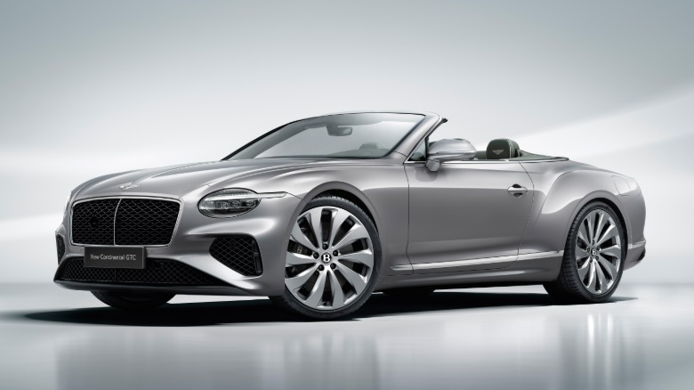 a silver bentley continental gtc parked in a studio with its top down