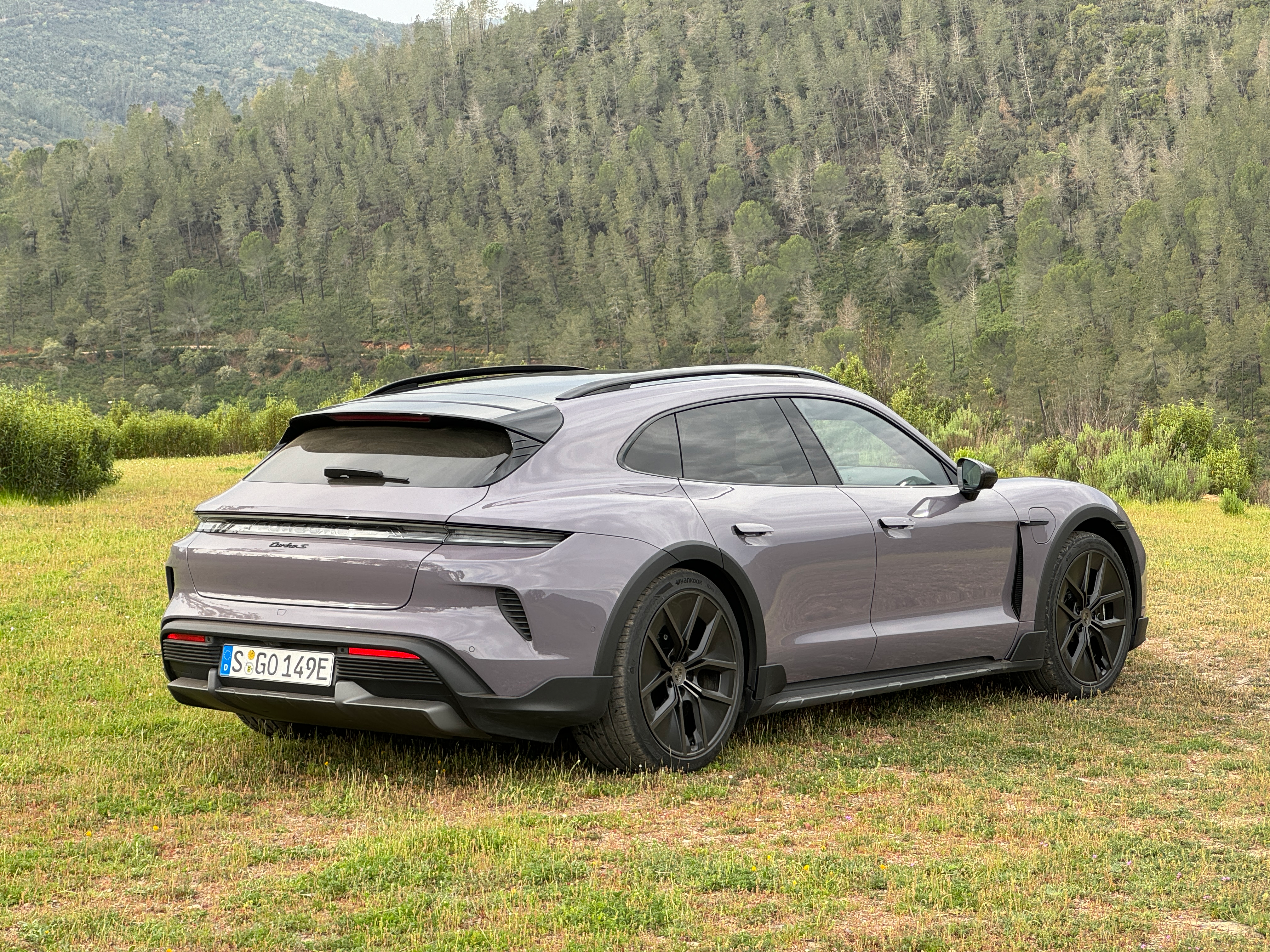 Rear 3/4 view of a lavender 2025 Porsche Taycan Turbo S Cross Turismo